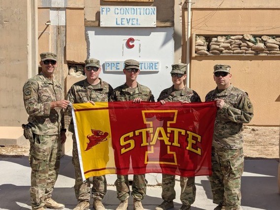 Deployed ISU Students hold ISU flag in another country